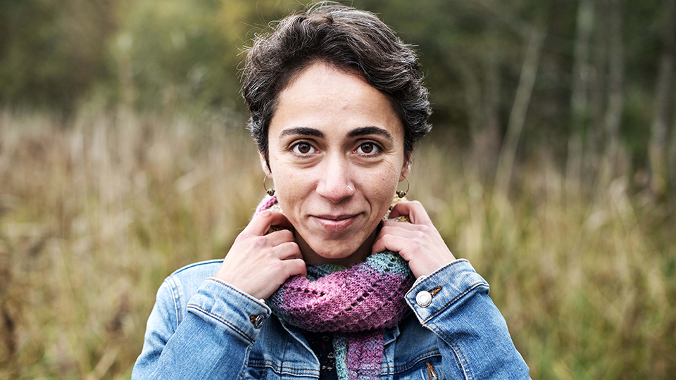 Porträttfoto av Aslı Ceren Aslan som har en jeansjacka och en lila stickad halsduk på sig. 