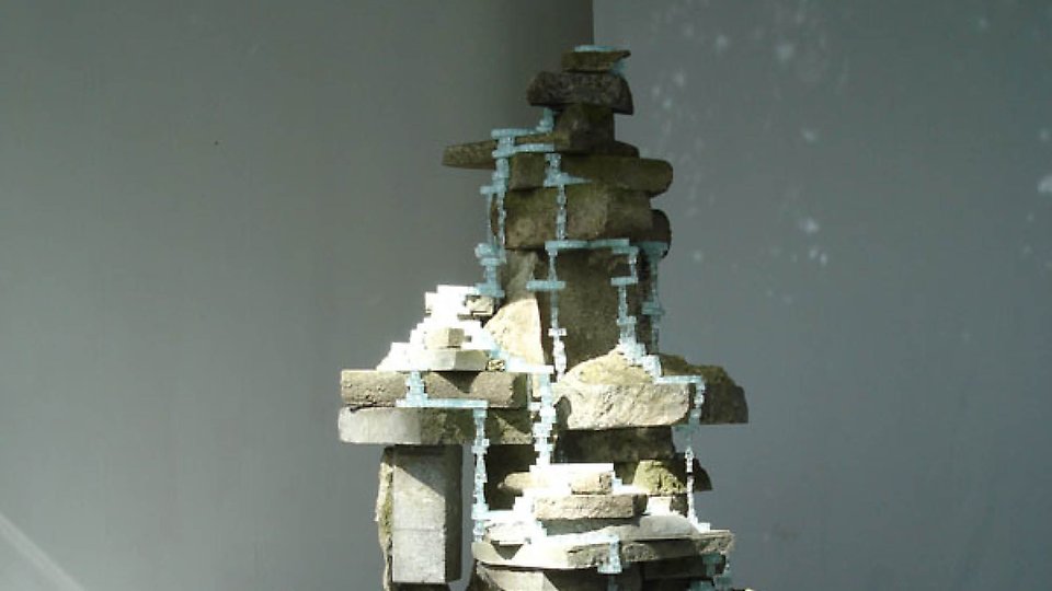 Foto på en skulptur uppbyggd av spillbitar från betongbitar och glassplitter.