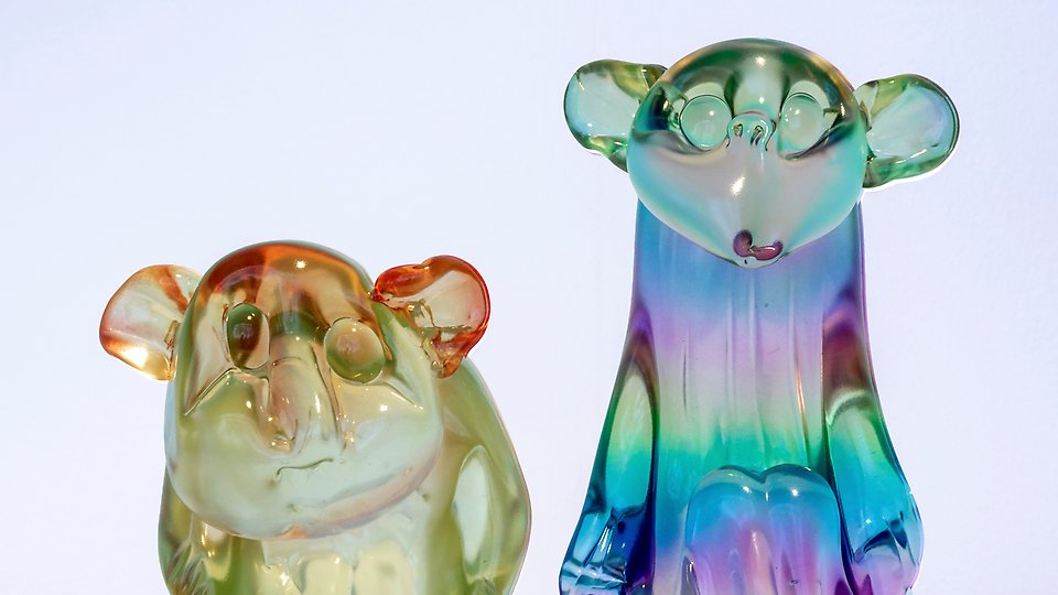 Två djurskulpturer i glas i regnbågsfärg. 